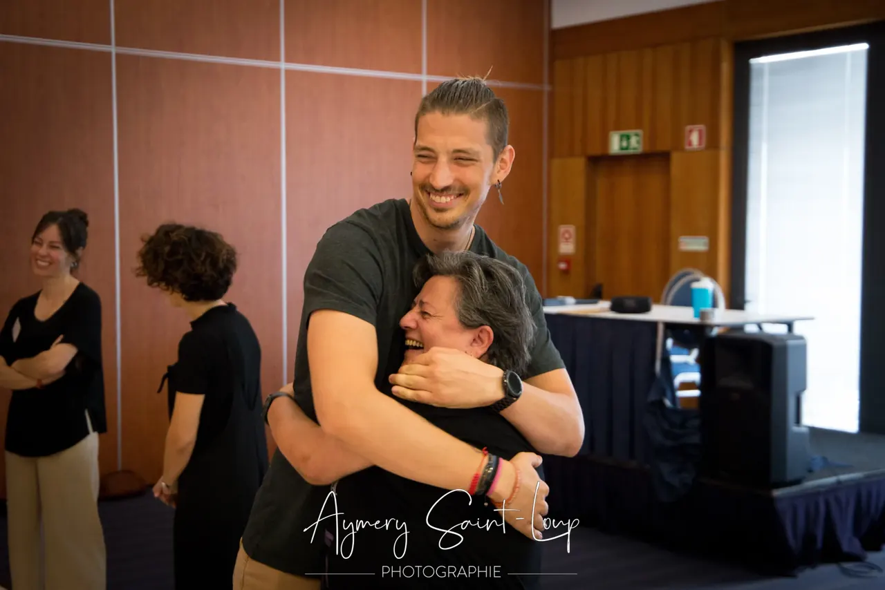 Dois participantes abraçados e sorridentes durante um encontro