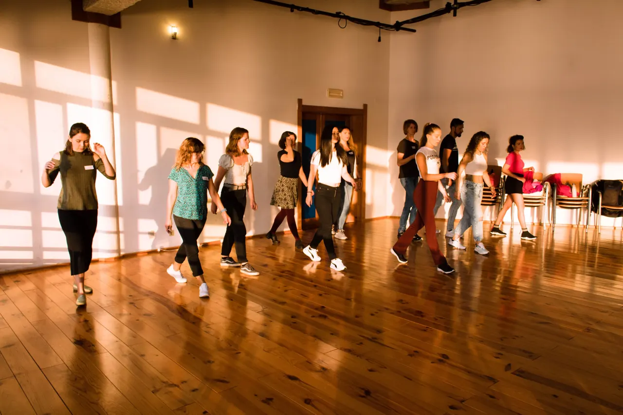 Participantes a aprender West Coast Swing numa sala com chão de madeira